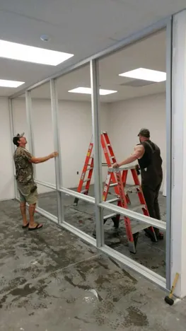 Image of our technicians installing framing for interior office glass walls